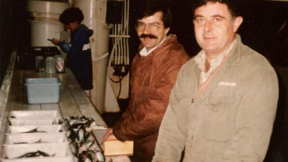 Tres persoas, entre elas, Antonio Vázquez, traballando nunha liña de traballo nun pesqueiro. 