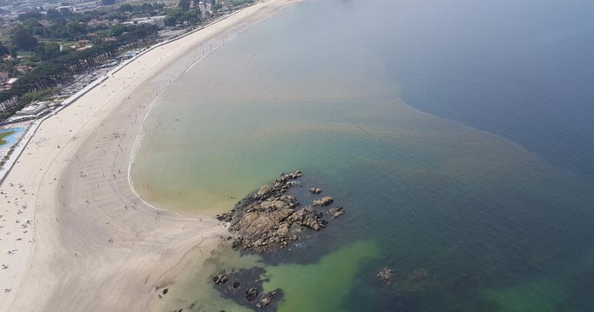 Costa da praia de Samil coloreada por mareas vermellas.